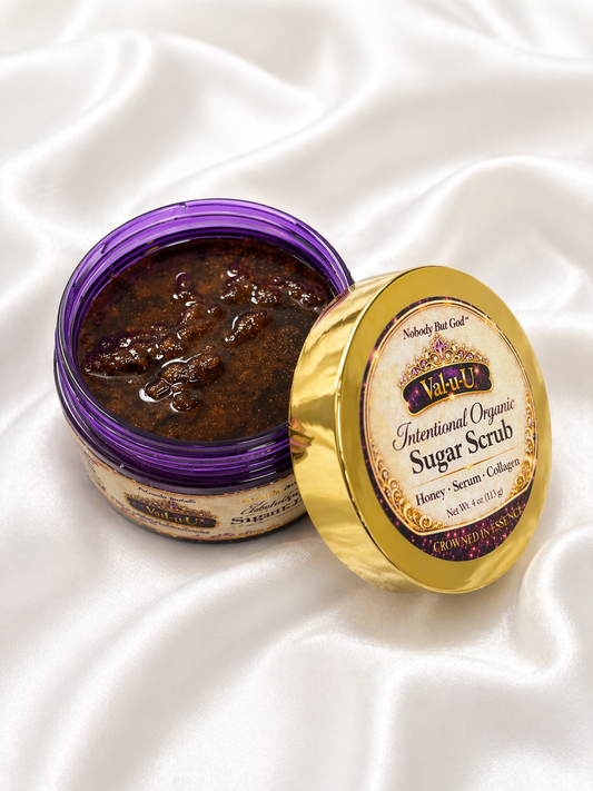 Jar of sugar scrub with gold lid on a white satin background